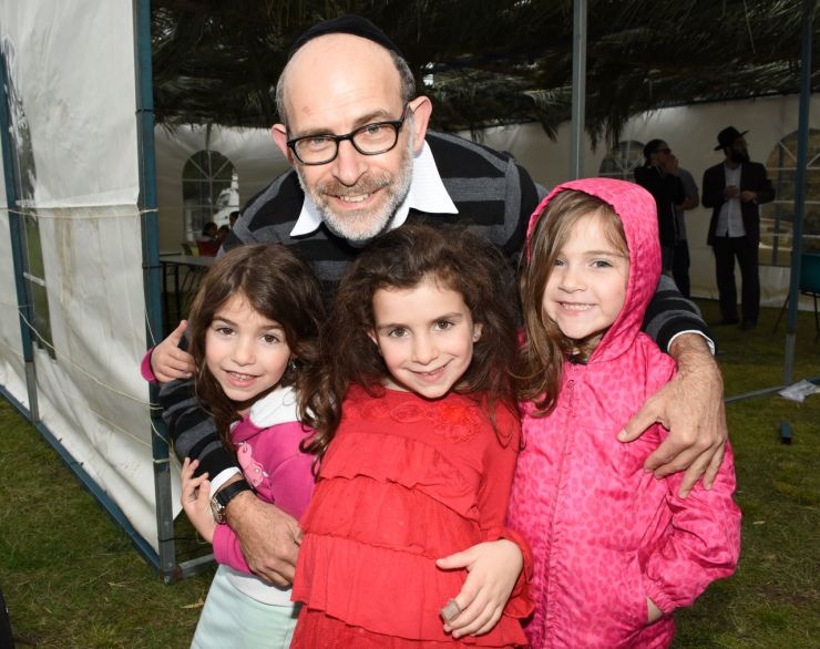 Pizza in the Sukkah communal Succot Party. Royce Isacowitz with his daughters Elisheva, Tzofia, Yael.